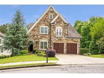Beautiful stone home with manicured lawn, two-car garage, and mature landscaping at 2370 Bradwardine Ct, Cumming, GA 30041