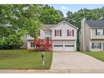 Charming home with red shutters, a two-car garage, mature trees, and a quaint, covered front porch at 2746 Sanibel Se Ln, Smyrna, GA 30082