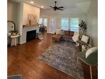 Inviting living room with fireplace, ceiling fan, plush seating, and ample natural light at 110 Peach Pointe Dr, Mcdonough, GA 30253
