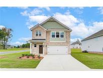 Charming two-story home with neutral brick, landscaped yard, and attached two car garage at 324 Tulip Dr, Covington, GA 30016