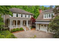 Charming home with a welcoming front porch and attached garage; beautiful landscaping at 9179 Selborne Ln, Chattahoochee Hills, GA 30268
