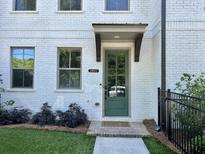 Charming townhouse entrance with a painted white brick facade and a decorative sage-green door at 2893 Elmwood Dr, Smyrna, GA 30080