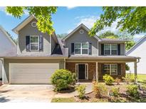 Charming two-story home featuring gray siding, black shutters, brick accents, and a well-maintained front yard at 4065 Waters End Ln, Snellville, GA 30039