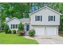 Charming home with a two-car garage, beautiful landscaping and a welcoming entrance at 5590 Princeton Oaks Dr, Sugar Hill, GA 30518