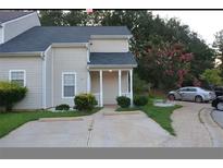 Charming townhouse featuring a well-maintained lawn, a private driveway and a cozy front porch at 6460 Wellington Chase Ct, Lithonia, GA 30058