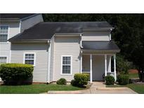 Traditional two-story townhouse with beige siding, dark roof and landscaped front yard at 6460 Wellington Chase Ct, Lithonia, GA 30058