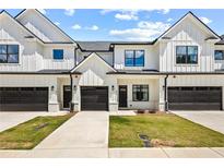 Modern townhome exterior with white siding, black accents, and individual garages at 208 Starr Cir, Stockbridge, GA 30281