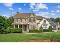 Charming two-story home with brick and siding exterior, lush landscaping, and a well-manicured lawn at 3915 Northridge Dr, Cumming, GA 30040