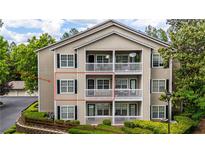 Attractive condo building with multiple units, decks, black shutters, and landscaped greenery surrounding the property at 1250 Parkwood Se Cir # 1203, Atlanta, GA 30339
