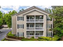 Three-story condo building showcasing balconies, black shutters and tidy landscaping at 1250 Parkwood Se Cir # 1203, Atlanta, GA 30339