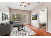 Bright living room featuring hardwood floors, large window, and access to the outdoor deck at 1250 Parkwood Se Cir # 1203, Atlanta, GA 30339