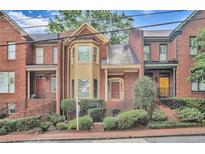 Charming brick townhome with meticulously landscaped front yard and welcoming entrances to all units at 249 Sycamore Pl, Decatur, GA 30030