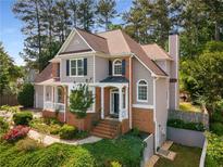 Charming two-story home featuring a brick and siding exterior, landscaped front yard, and inviting front porch at 825 Yosemite Dr, Suwanee, GA 30024