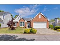 Charming brick home with a well-maintained front yard and a two-car garage in a great neighborhood at 11865 Brisbane Dr, Alpharetta, GA 30009