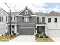 Charming townhome with a gray facade, white trim, well-manicured lawn, and a two-car garage at 1717 Cosette Ln, Kennesaw, GA 30152