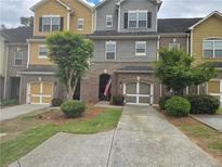 Charming townhome with brick accents, a garage, and a well-manicured front yard at 106 Trailside Way, Hiram, GA 30141