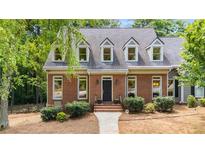 Charming brick front exterior with well-maintained landscaping and black front door at 1061 Polo Club Nw Dr, Marietta, GA 30064