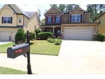 Charming two-story home with a manicured lawn and two car garage at 3877 Lake Sanctuary Way, Atlanta, GA 30349