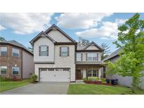 Charming two-story home with a two-car garage, manicured lawn and brick and siding accents at 1867 Castleberry Ln, Buford, GA 30518