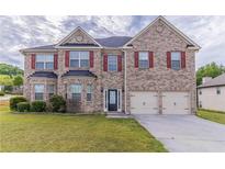 Charming two-story brick home with a well-manicured lawn and attached two-car garage at 204 Saintvry Path, Atlanta, GA 30349