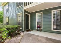 Charming home exterior with green siding, trimmed windows, and a welcoming porch adorned with vibrant flowers at 2814 Vinings Central Se Dr # 151, Atlanta, GA 30339
