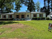 Charming single-story home with a manicured lawn, complemented by wooden accents and lush green shrubbery at 2678 Stardust Trl, Decatur, GA 30034