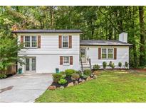 Charming home with white siding, brick accents, manicured lawn, and beautiful landscaping at 4723 N Springs Nw Rd, Kennesaw, GA 30144