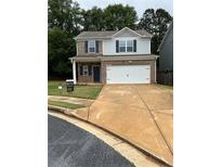 Charming two-story home featuring a brick facade, neutral siding, and a well-maintained lawn at 10786 Wheeler Trce, Hampton, GA 30228