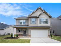 Charming two-story home with gray siding, a covered porch, two car garage and a well-manicured lawn at 196 Boulder Run, Hiram, GA 30141