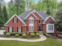 Beautiful brick home with manicured lawn, double front door, and mature landscaping gives great curb appeal at 250 Chason Wood Way, Roswell, GA 30076