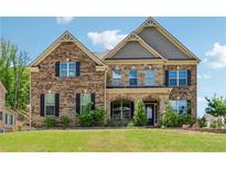 Traditional two-story brick home with a manicured lawn and black shutters, offering classic curb appeal at 2410 Bridle Bridge Trl, Cumming, GA 30040