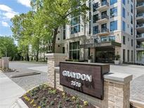 Luxury condo building, Graydon 2520, with elegant landscaping and brick entryway at 2520 Peachtree Nw Rd # 403, Atlanta, GA 30305