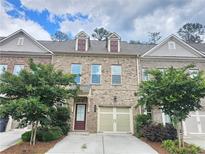 Attractive brick townhouse with a well-maintained lawn and a one car garage at 261 Mahone Dr, Lilburn, GA 30047
