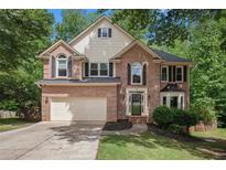 Charming two-story brick home featuring an attached two-car garage and a well-maintained front lawn at 300 Wesfork Nw Way, Suwanee, GA 30024