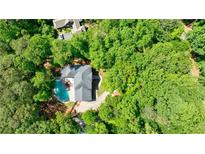 Aerial view of private residence with a backyard swimming pool surrounded by lush, mature trees at 1348 Timberland Se Dr, Marietta, GA 30067