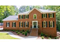 Stunning brick home with dark shutters, lush landscaping, and inviting front entrance stairs at 1348 Timberland Se Dr, Marietta, GA 30067