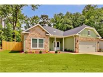 Charming home featuring stone accents, fresh green grass and a well-manicured yard at 6022 Fieldcrest Dr, Morrow, GA 30260