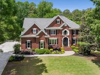 Elegant brick home featuring manicured landscaping and a classic architectural design at 10410 High Falls Cir, Alpharetta, GA 30022
