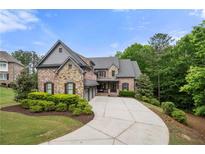 Stunning brick home with a concrete driveway and well-manicured lawn at 12980 Overlook Pass, Roswell, GA 30075