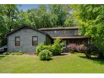Charming two-story home with landscaped yard and mature trees in a serene, wooded setting at 1429 Smithson Dr, Lithonia, GA 30058