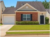 Charming single Gathering home with brick facade, well-manicured lawn, and an attached garage with driveway at 1015 Lakeside Cir, Covington, GA 30016