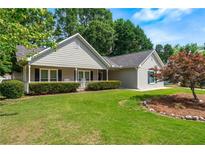 Charming single story home with manicured lawn, mature trees, and inviting front porch at 130 Lacey Oak Ln, Loganville, GA 30052