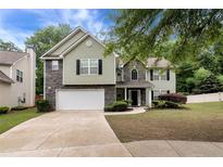 Charming two-story home with a two-car garage, landscaped front yard, and a combination of siding and stone exterior at 3265 Watson Gate Rd, Loganville, GA 30052