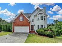 Charming two-story home features brick and vinyl siding with an attached two-car garage at 1405 Bramlett Forest Trl, Lawrenceville, GA 30045