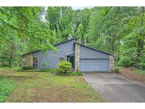 Charming gray home with stone accents, mature trees, and a two-car garage at 1515 Barrier Rd, Marietta, GA 30066