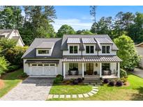 Beautiful home with a white exterior, metal roof accents, and a welcoming front porch at 2373 Sagamore Hills Dr, Decatur, GA 30033