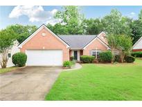 Charming single-story brick home with a well-manicured lawn and an attached two-car garage at 75 Saltcreek Pt, Sugar Hill, GA 30518
