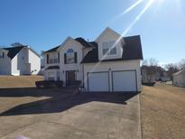 Charming two-story home with a well-maintained lawn and an attached two-car garage at 6179 Swabia Ln, Stone Mountain, GA 30087