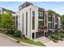 Contemporary townhome boasts white painted brick, black trim, private balconies, and a two-car garage at 307 Cedar Dust Dr, Decatur, GA 30030