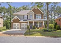Charming two-story brick home with a well-manicured lawn, a two-car garage, and a welcoming front porch at 4765 Silver Leaf Dr, Cumming, GA 30040
